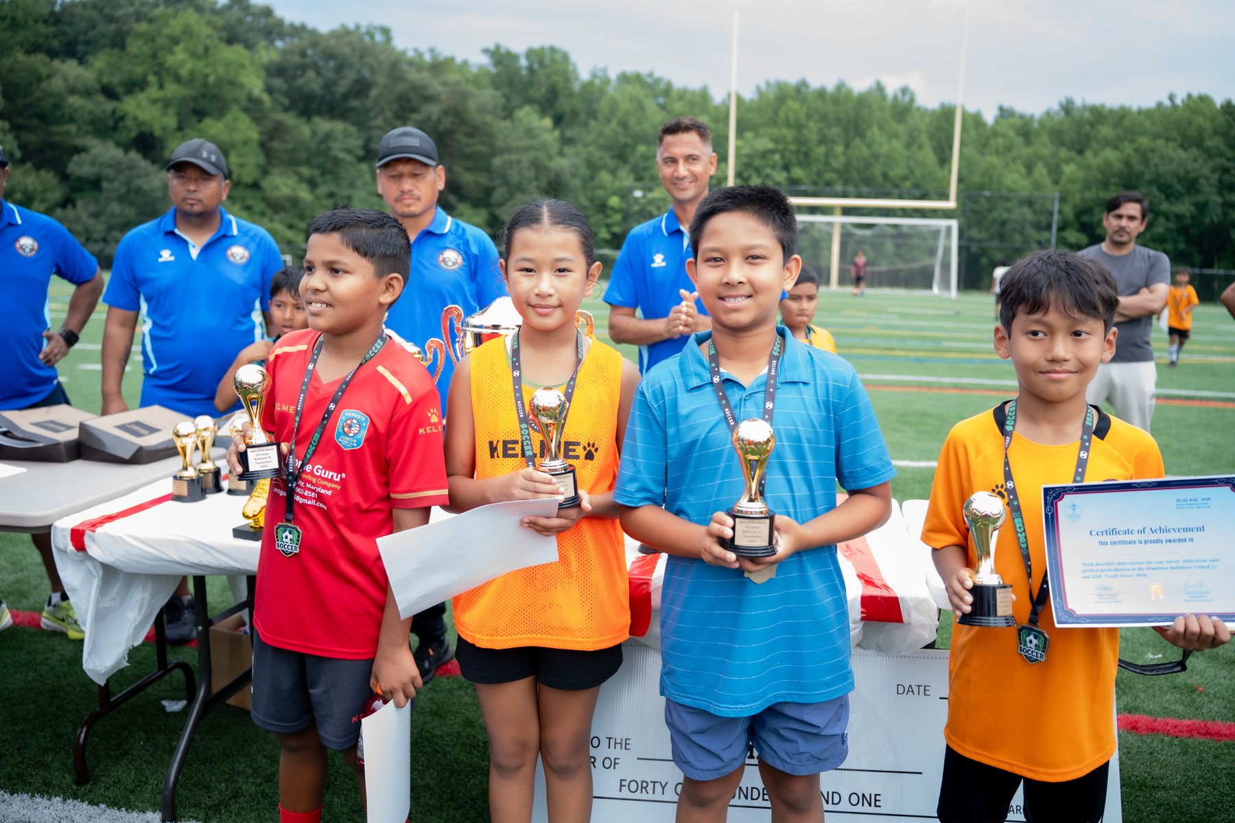 Young players holding individual trophies and certificates